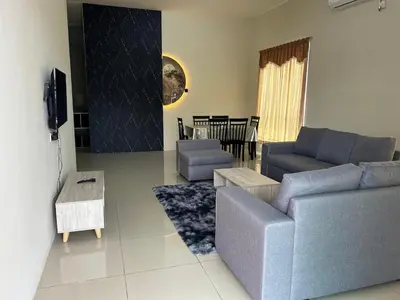 a living room with a couch and a tv at RB Homestay Modern Comfort in Hutan Melintang