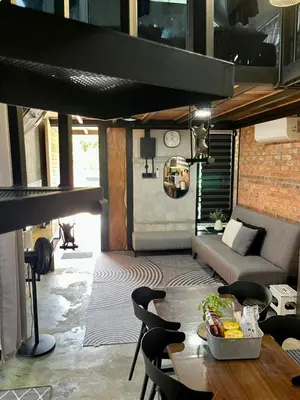 a living room with a table and chairs and a couch at Kurie Redbrick House in Balik Pulau