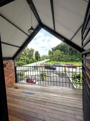 a view from the inside of a house with a wooden deck at Kurie Redbrick House in Balik Pulau