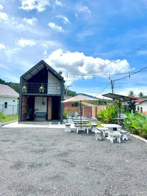 a group of tables and benches in front of a building at Kurie Redbrick House in Balik Pulau