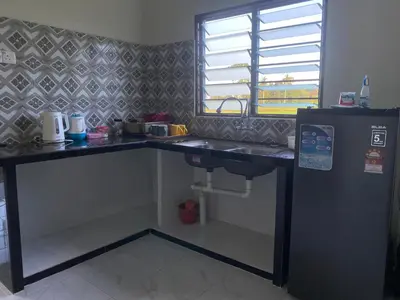 a kitchen with a counter with a sink and a window at Najib homestay