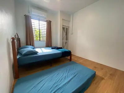 a bedroom with two beds and a window at Roomstay Cikgu Mie in Bayan Lepas