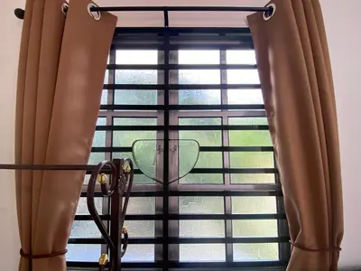 a window with brown curtains in a room at Roomstay Cikgu Mie in Bayan Lepas