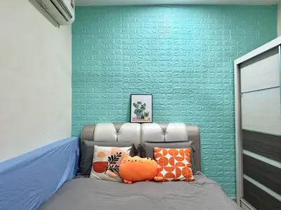 a bed in a room with a green wall at Specious Living Cozy House in Bukit Mertajam