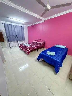 a room with two beds and a pink wall at M S Villa Homestay Ayer Tawar in Ayer Tawar
