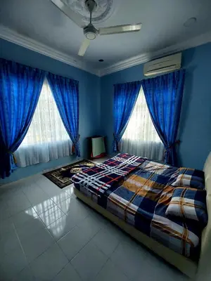 a bedroom with blue walls and a bed with blue curtains at ASTANA INN HOMESTAY Balik Pulau in Balik Pulau