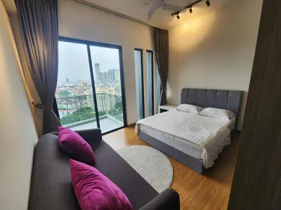 a bedroom with a bed and a couch and a window at Beacon Executive Suite Penang George Town in George Town