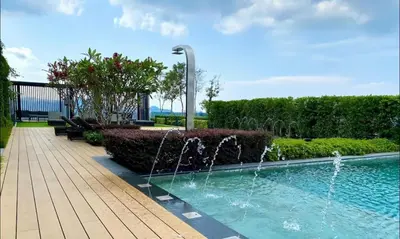 a swimming pool with a fountain in a garden at Beacon Executive Suite Penang George Town in George Town