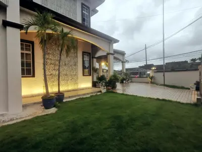 a house with a green yard with palm trees at Ryui's Quiet Bungalow - Room Only - No Extra Tax in Sungai Petani