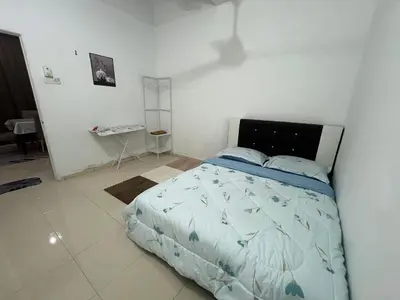 a bedroom with a bed in a white room at Ummu Homestay 03 in Batu Gajah