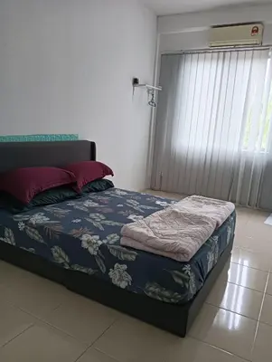 a bedroom with a bed with a blue comforter at Taman yu sungai besar in Sungai Besar