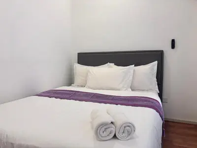 a bedroom with a bed with two towels on it at Theme Park Ipoh - Onsen Premier Suites By LUX SUITE in Ipoh