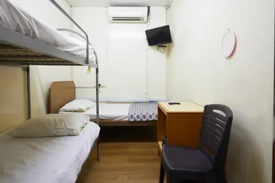 a small room with a bunk bed and a desk at Ros Heritage Motel in George Town