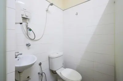 a white bathroom with a toilet and a sink at Ros Heritage Motel in George Town
