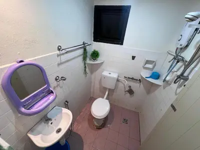a bathroom with a toilet and a sink and a mirror at KISABEL Budget Hotel in Tanah Rata