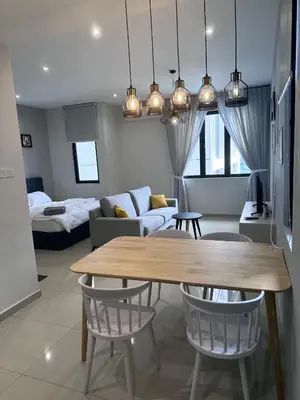 a living room with a table and a couch at Wanderlust Retreat Studio by Iconic Regency in Bayan Lepas