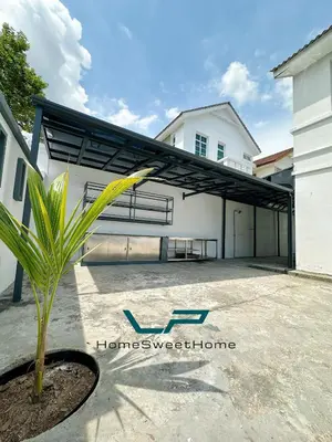 a house with a garage with a palm tree in the driveway at Penang Balik Pulau BBQ & KARAOKE Home in Balik Pulau
