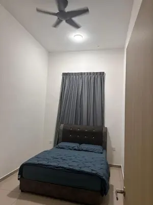 a bedroom with a bed with a ceiling fan at Xiang Homestay in Padang Serai