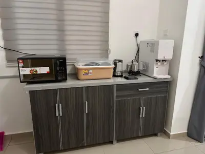a counter with a microwave and other appliances on it at Xiang Homestay in Padang Serai