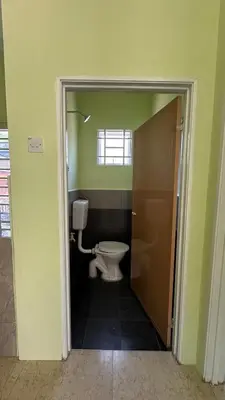 a bathroom with a toilet in a room with green walls at Baitul Ilmi Homestay in Kuala Kangsar