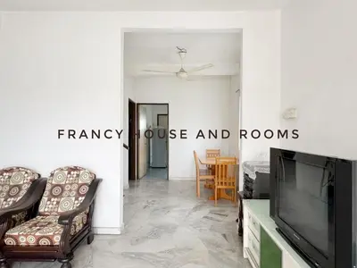 a living room with a flat screen tv and chairs at Nanyang Style Home In Ipoh in Ipoh