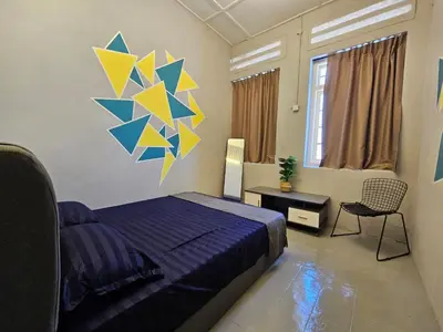 a bedroom with a bed and a painting on the wall at KITA Hostel in George Town
