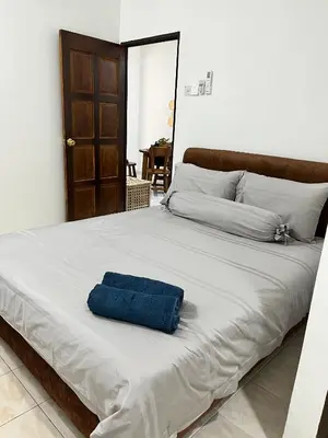 a bed with a blue towel on top of it at Saujana Number 5 in Gua Sai