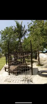 a net in front of a park with trees at By The Sea in Batu Ferringhi