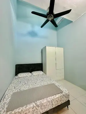 a bedroom with a bed and a ceiling fan at Ahnaf Guesthouse in Sitiawan