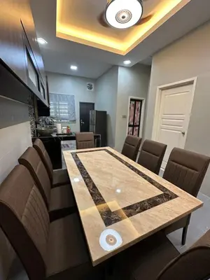 a dining room with a table and chairs at Ahnaf Guesthouse in Sitiawan