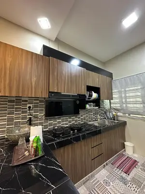 a kitchen with a black counter top and a microwave at Ahnaf Guesthouse in Sitiawan