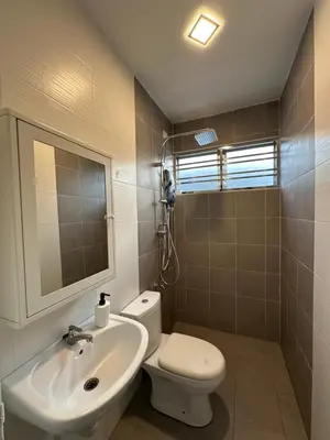 a bathroom with a sink and a toilet and a mirror at Ahnaf Guesthouse in Sitiawan