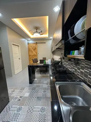 a kitchen with a sink and a table at Ahnaf Guesthouse in Sitiawan