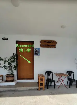 a wall with a door with a sign and two chairs at Sunya Home Basement Raub Pahang in Raub