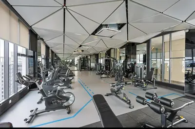 a gym with rows of cardio equipment in a building at Urban Studio 22Macalisterz- Washer and Nespresso in George Town