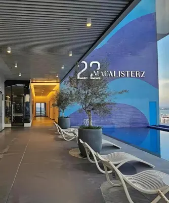 a lobby of a building with benches and a sign at Urban Studio 22Macalisterz- Washer and Nespresso in George Town