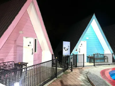 a group of three different colored buildings at night at Capital O 91167 Gemilang Candi Resort in Kampong Baru
