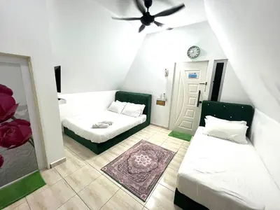a small room with two beds and a ceiling fan at Capital O 91167 Gemilang Candi Resort in Kampong Baru