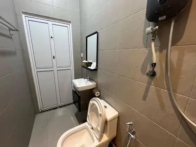 a bathroom with a toilet and a sink at Capital O 91170 Kurau Bay Hotel in Kuala Kurau