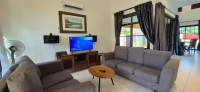 a living room with two couches and a flat screen tv at Striatus by Holiday Pool Villa A'Famosa Resort in Gua Sai