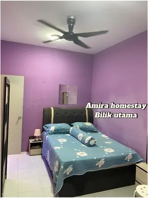 a bedroom with purple walls and a bed with pillows at Amira homestay in Kampong Batu Lima