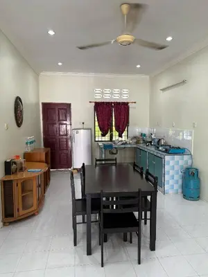a kitchen with a table and chairs in a room at Homestay Maahad Tahfiz Kemukjizatan Al-Quran in Gerik