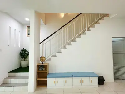 a living room with a blue bench under a staircase at ipoh setia homestay in Ipoh