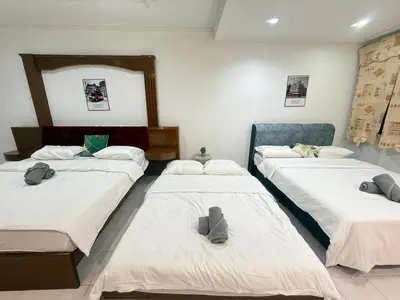 a room with three beds with hats on them at Cozy Family Home Seberang Jaya in Kampong Bagan Dalam