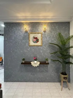 a wall with a picture and a potted plant on it at Cozy Family Home Seberang Jaya in Kampong Bagan Dalam