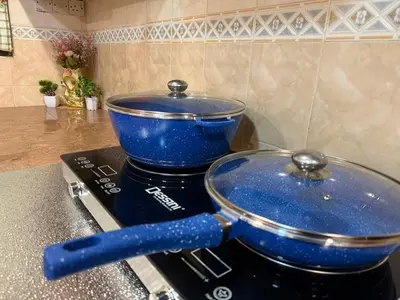 a blue pot sitting on top of a stove at Cozy Family Home Seberang Jaya in Kampong Bagan Dalam