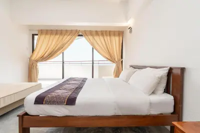 a bedroom with a bed with a large window at Seaview 3 room Apartment Batu Ferringhi in Batu Ferringhi