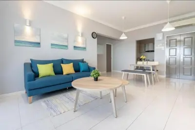 a living room with a blue couch and a table at Seaview 3 room Apartment Batu Ferringhi in Batu Ferringhi