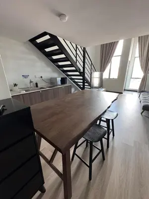 a dining room with a wooden table and chairs at Modern Studio The CEO Penang in Bayan Lepas