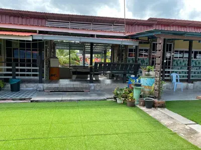 a house with a yard with green grass at Galeri Merah Teratak Anak Amas in Sungai Besar